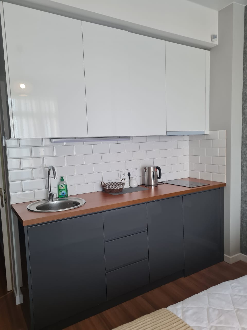 White Sails 6th floor apartment kitchen dark cabinets subway tile backsplash induction hob kettle