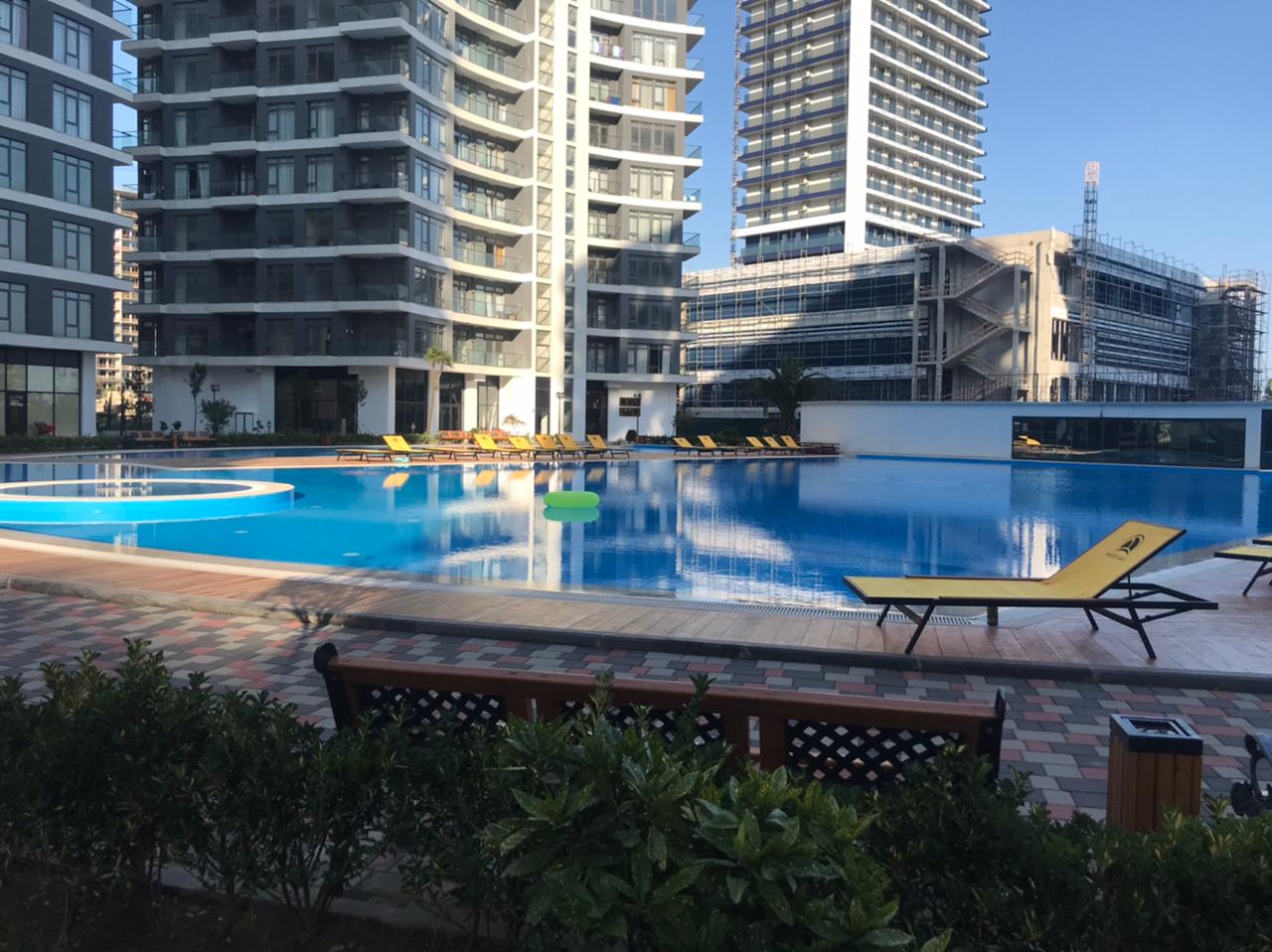 White Sails Batumi resort outdoor pool sun loungers residential towers blue sky
